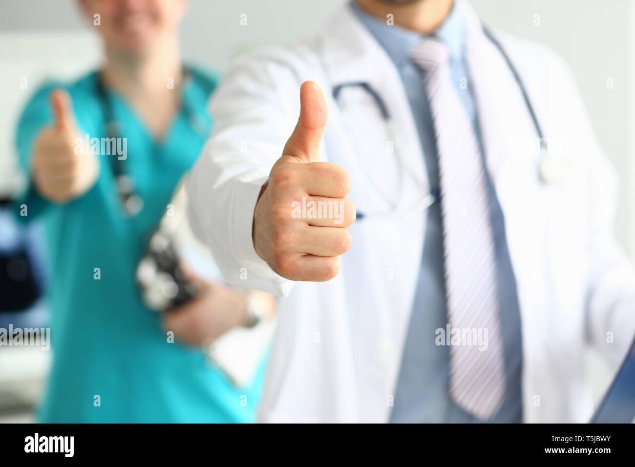 Zwei Ärzte zeigen Daumen oben-Geste mit den Händen Stockfoto