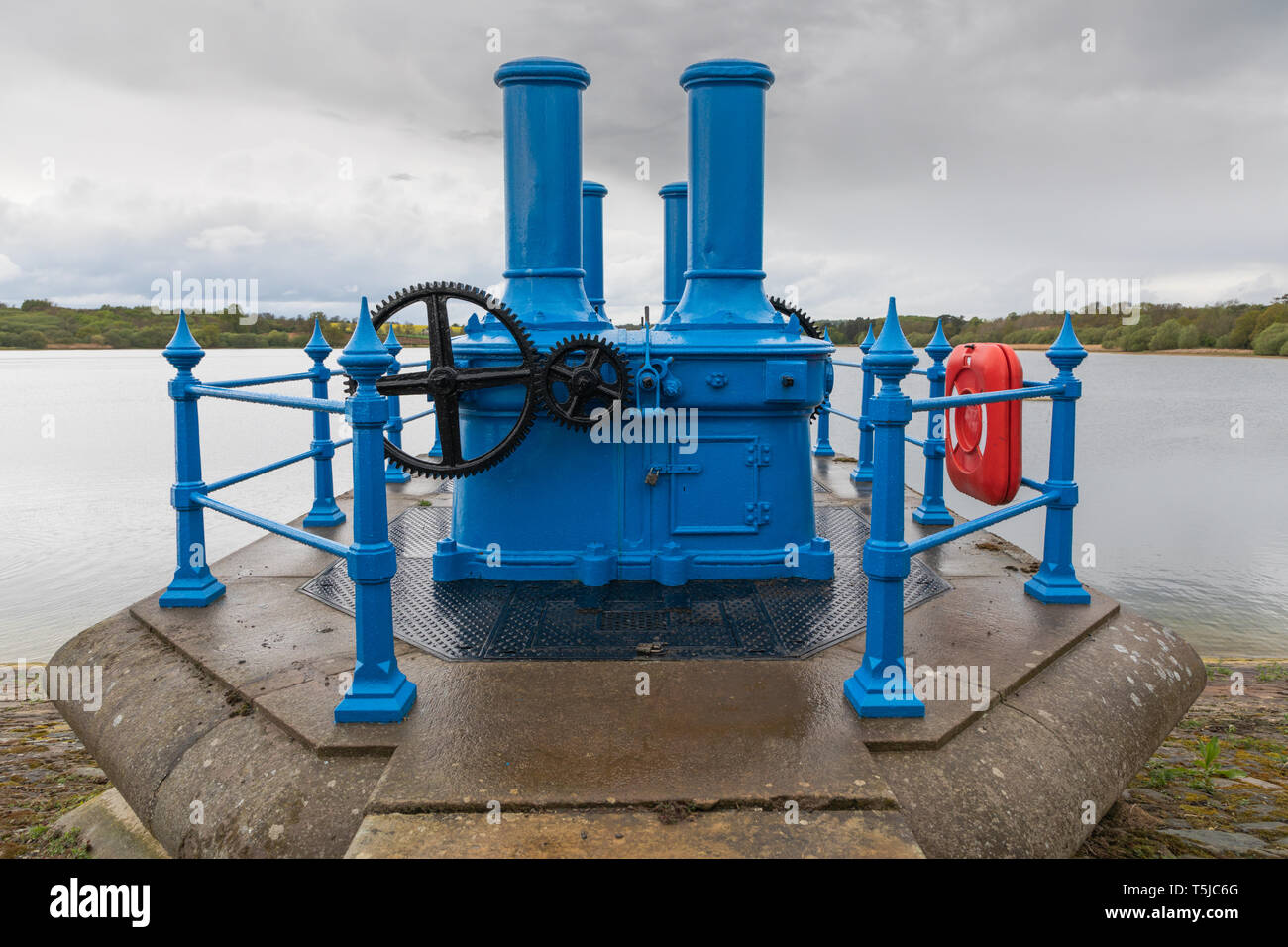 Ravensthorpe, Northamptonshire/UK - 25. April 2019: blaues Ventil und Gehäuse mit schwarzer Zahnräder im Regenwasser Tröpfchen unter einem bleiernen Himmel bedeckt. Stockfoto