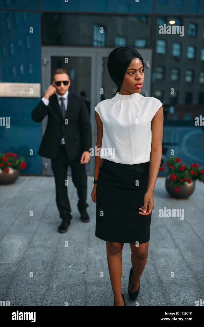 Schwarz Business woman Leibwächter in Anzug und Sonnenbrille auf Hintergrund. Security Guard ist eine riskante Beruf, Schutz der VIPs, guarding Besetzung, Pr Stockfoto