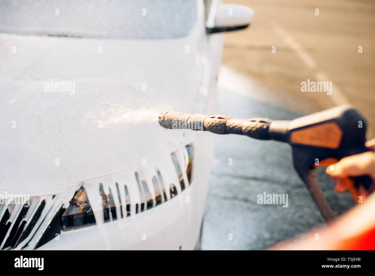 Weibliche Person Abwaschen der Schaum aus dem Auto. Junge Frau auf Self-service-Auto waschen. Outdoor Fahrzeug reinigen Stockfoto