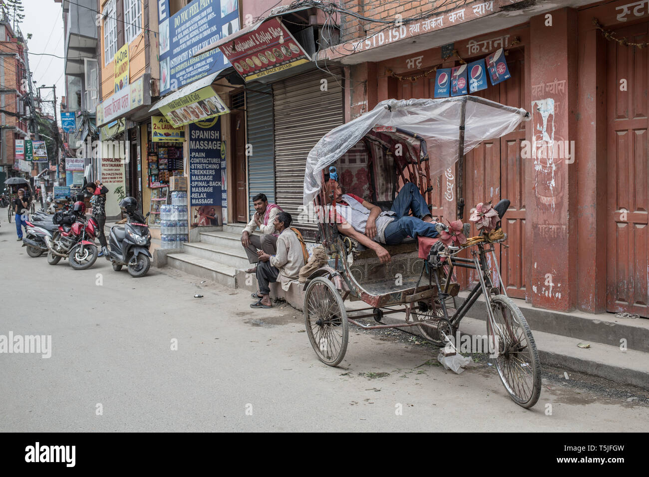 Eine Rikscha Fahrer schlafend in seinem Fahrrad in der Innenstadt von Kathmandu Stockfoto