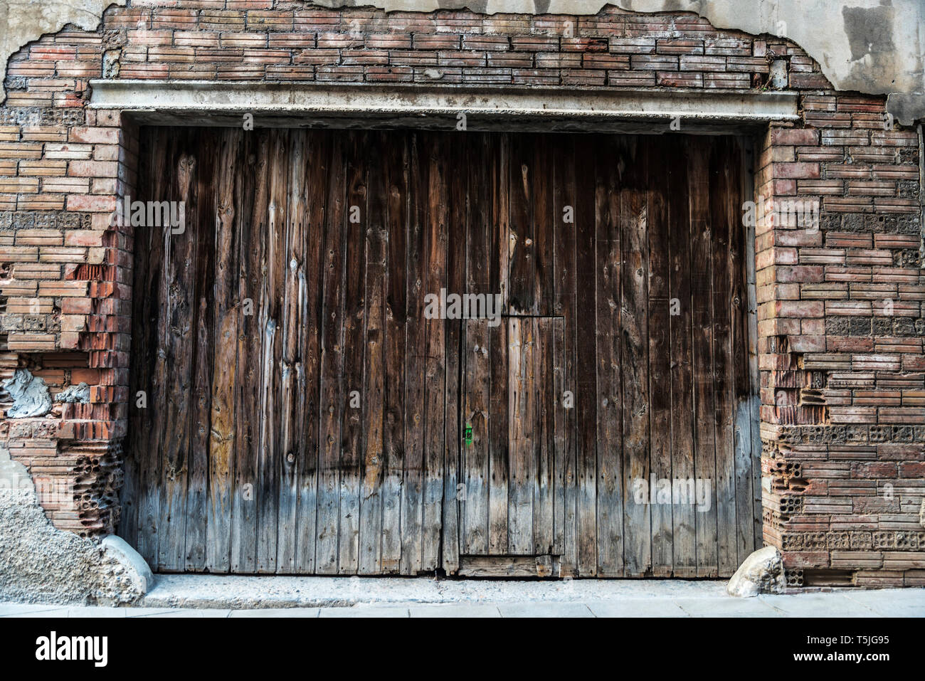 Alte Risse im Holz von Garage als Hintergrund in der Altstadt der mittelalterlichen Stadt Cardona in Katalonien, Spanien Stockfoto