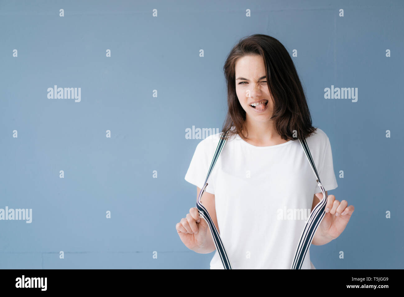 Frau ziehen lustige Gesichter, Stretching Hosenträger Stockfoto