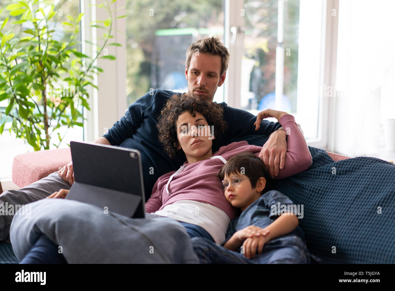 Familie liegen auf der Couch watching Film auf Imit tablet Stockfoto