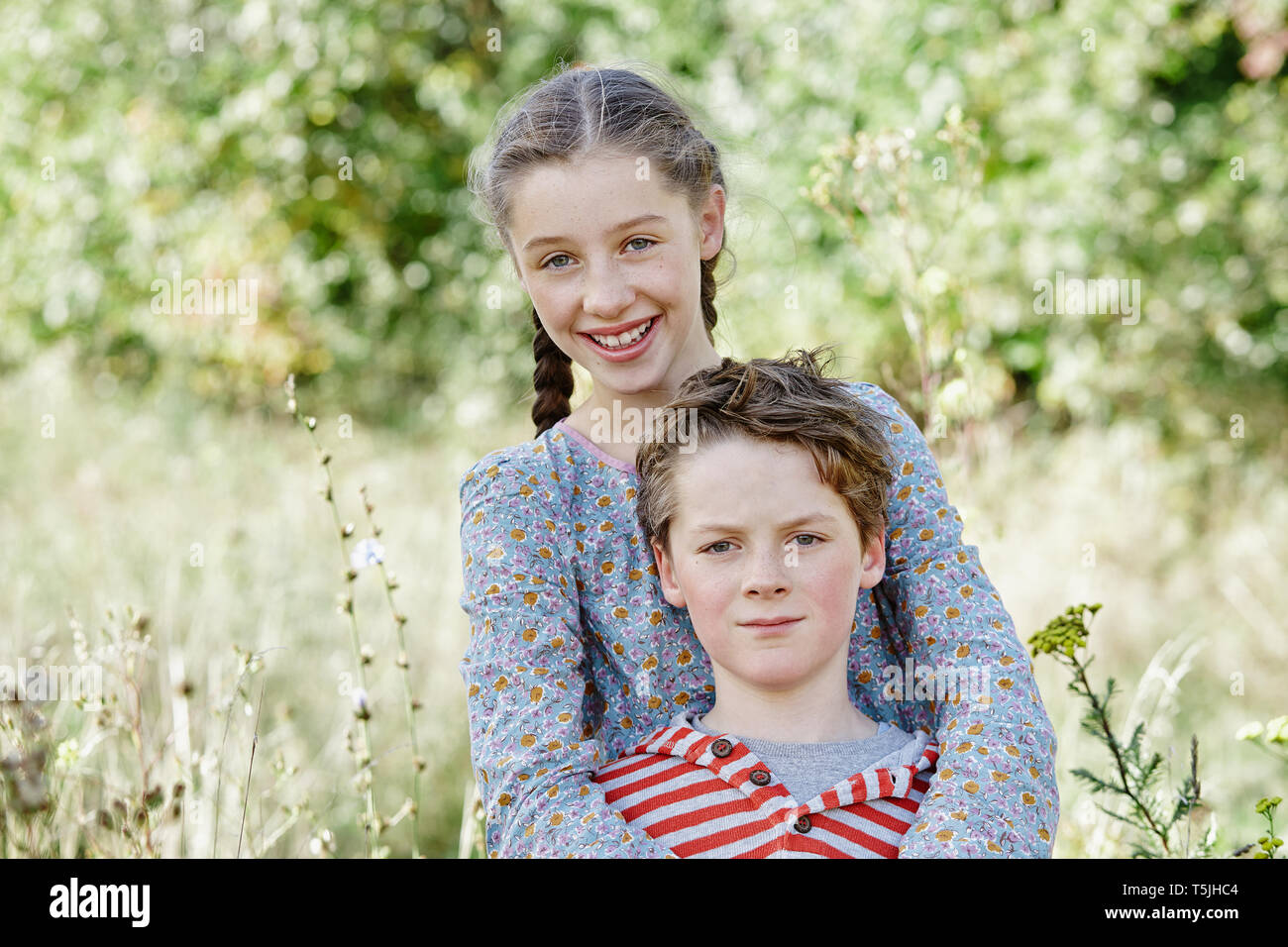 Portrait von Mädchen und kleiner Bruder in der Natur Stockfoto