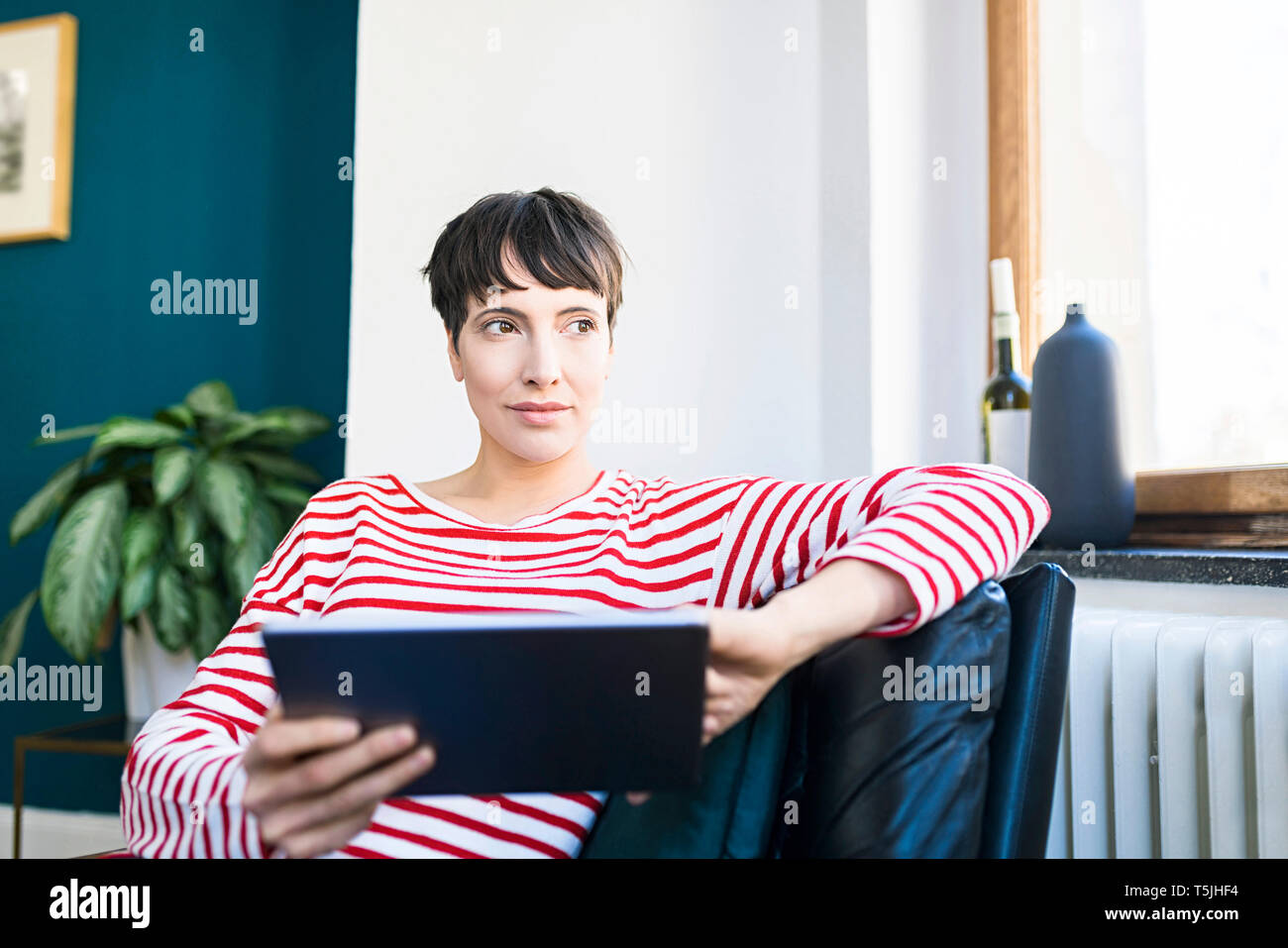 Kurzhaarige Frau Entspannen im Liegestuhl holding Tablet Stockfoto