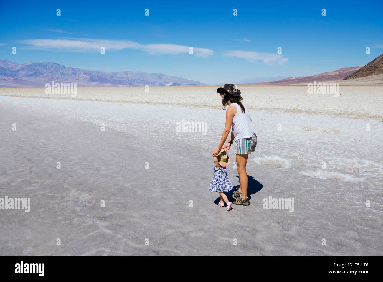 USA, Kalifornien, Death Valley National Park, Badwater Basin, Mutter und Baby Mädchen gehen in Salt Basin Stockfoto