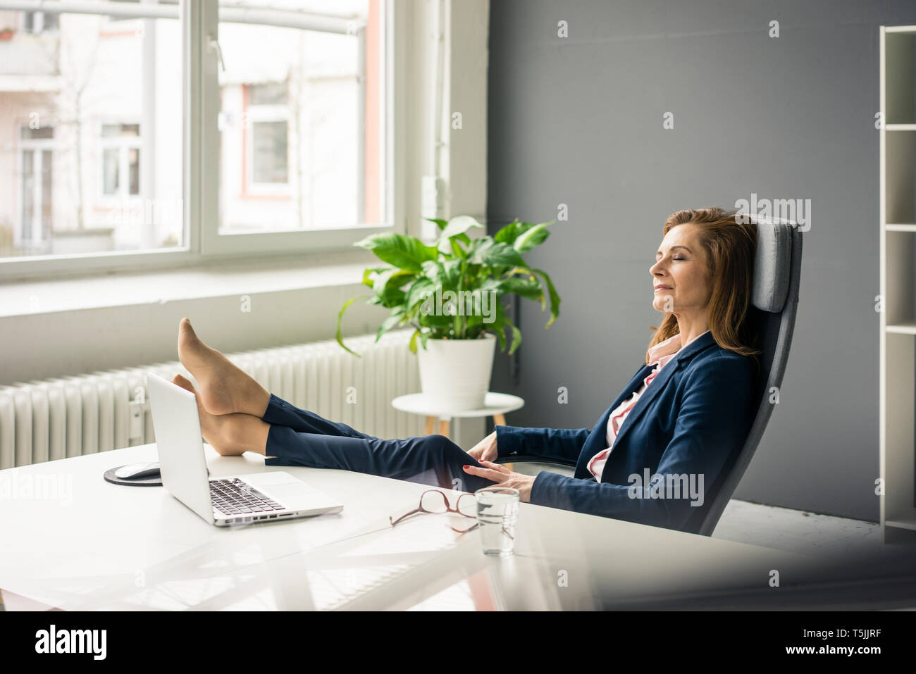 Geschäftsfrau entspannen im Büro mit Fuß oben Stockfoto