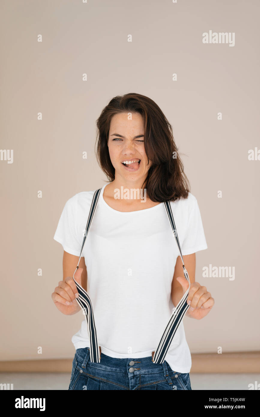 Frau ziehen lustige Gesichter, Stretching Hosenträger Stockfoto