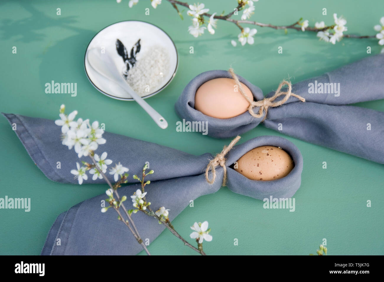 Ostern Dekoration, Zweige von schlehe, Servietten mit Ostereiern, gefaltet als Rabbit Ears Stockfoto