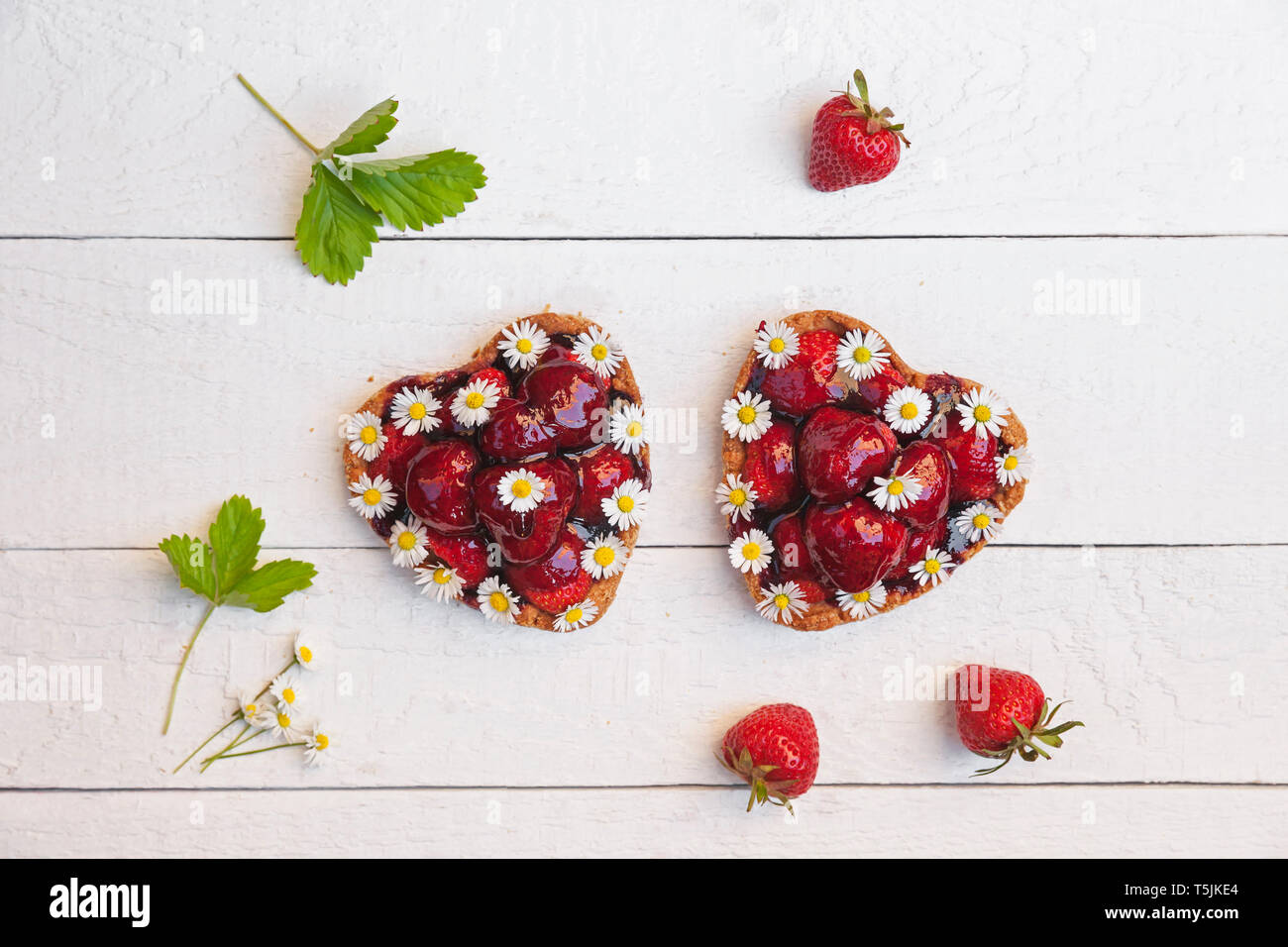 Selbstgemachte Erdbeer Herz Kuchen mit Daisy Blüten, essbare Blüten Stockfoto