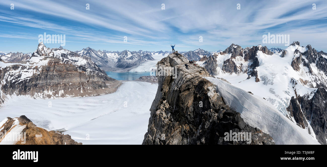 Grönland, Sermersooq, Kulusuk, Schweizerland Alpen, Bergsteiger mit erhobenen Armen auf dem Gipfel Stockfoto