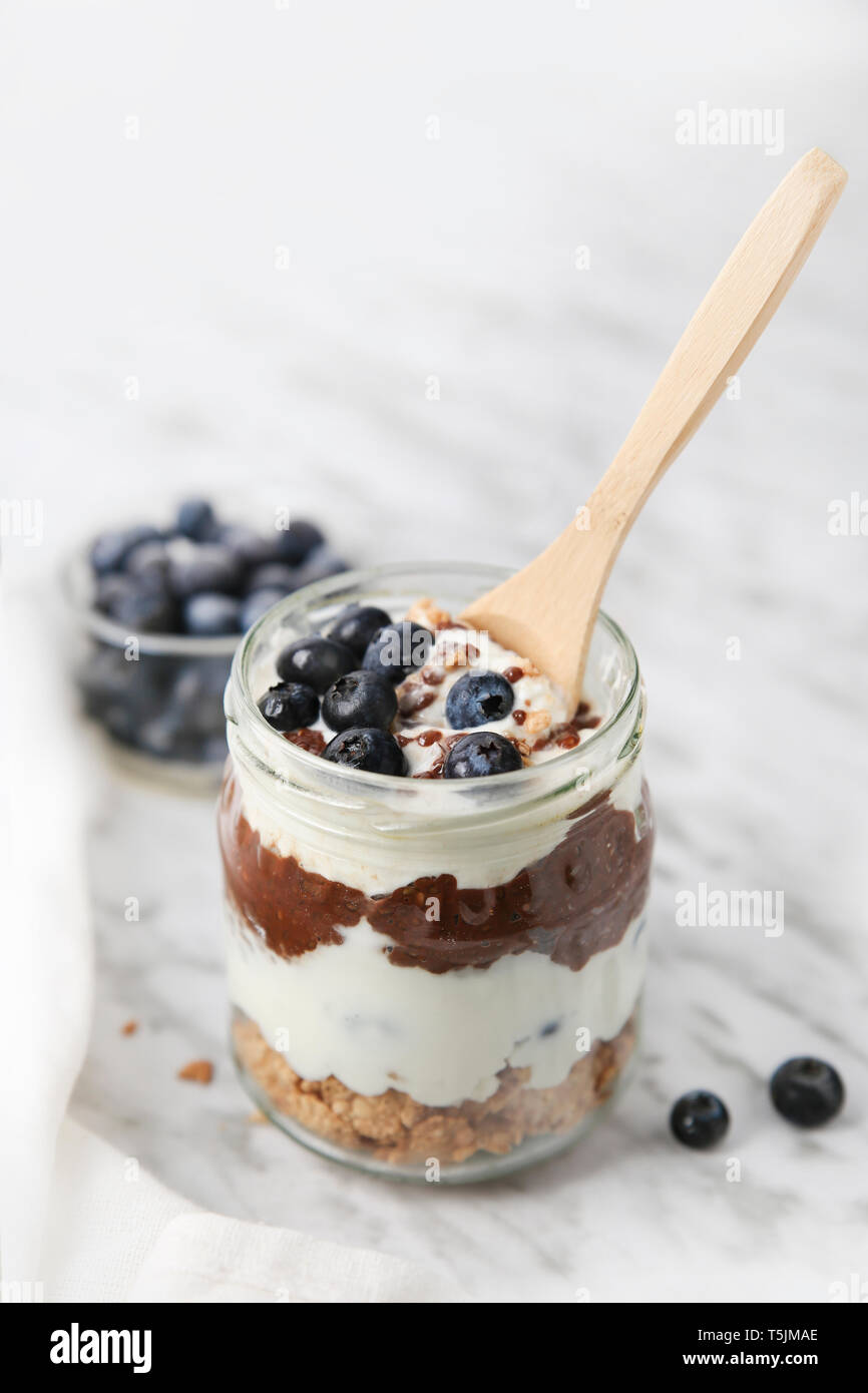 Jar von Chia pudding Parfait mit Schokolade und Joghurt mit Blaubeeren und Müsli Stockfoto