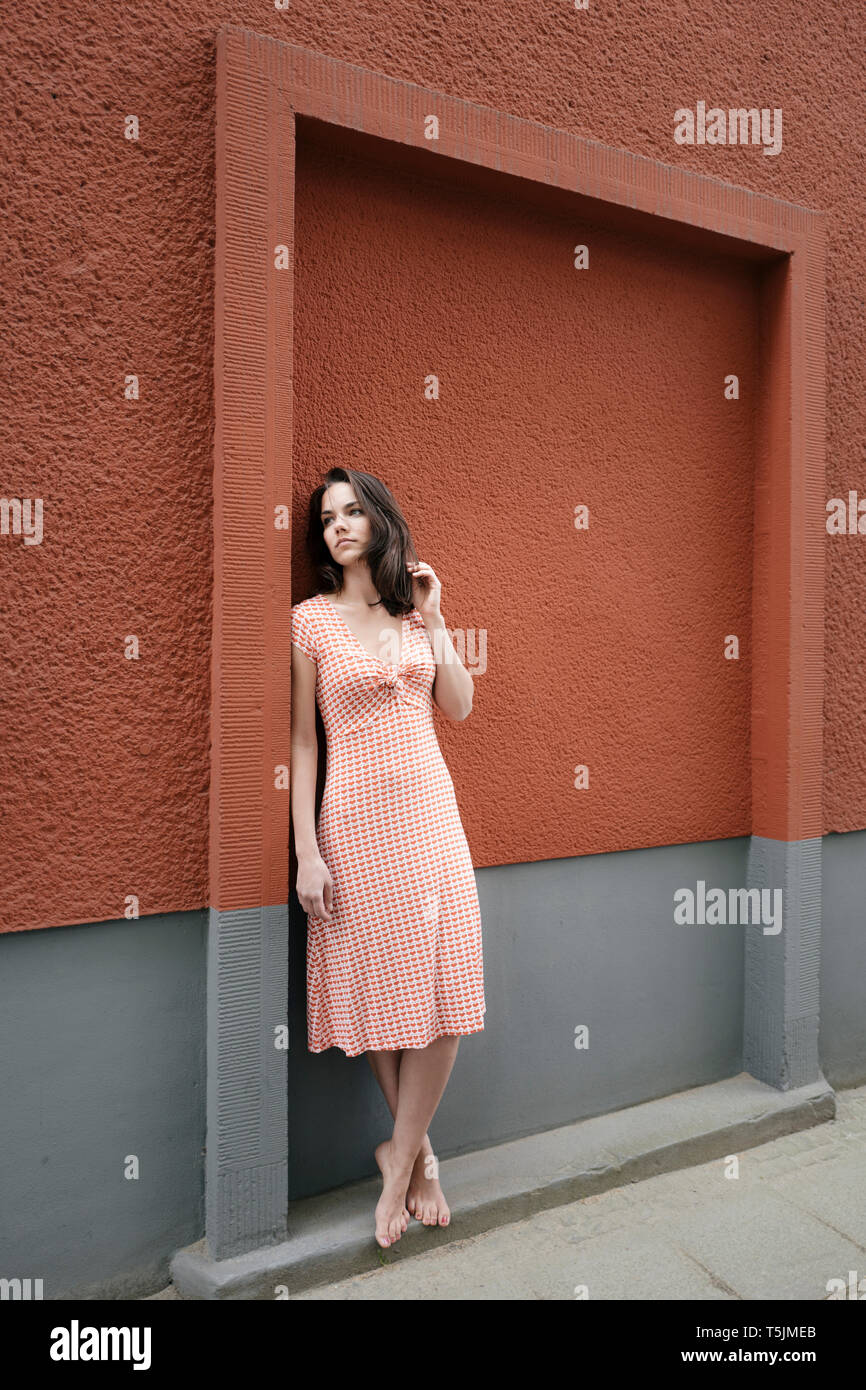 Pretty Woman Standing in der Straße, lehnte sich an der Wand Stockfoto