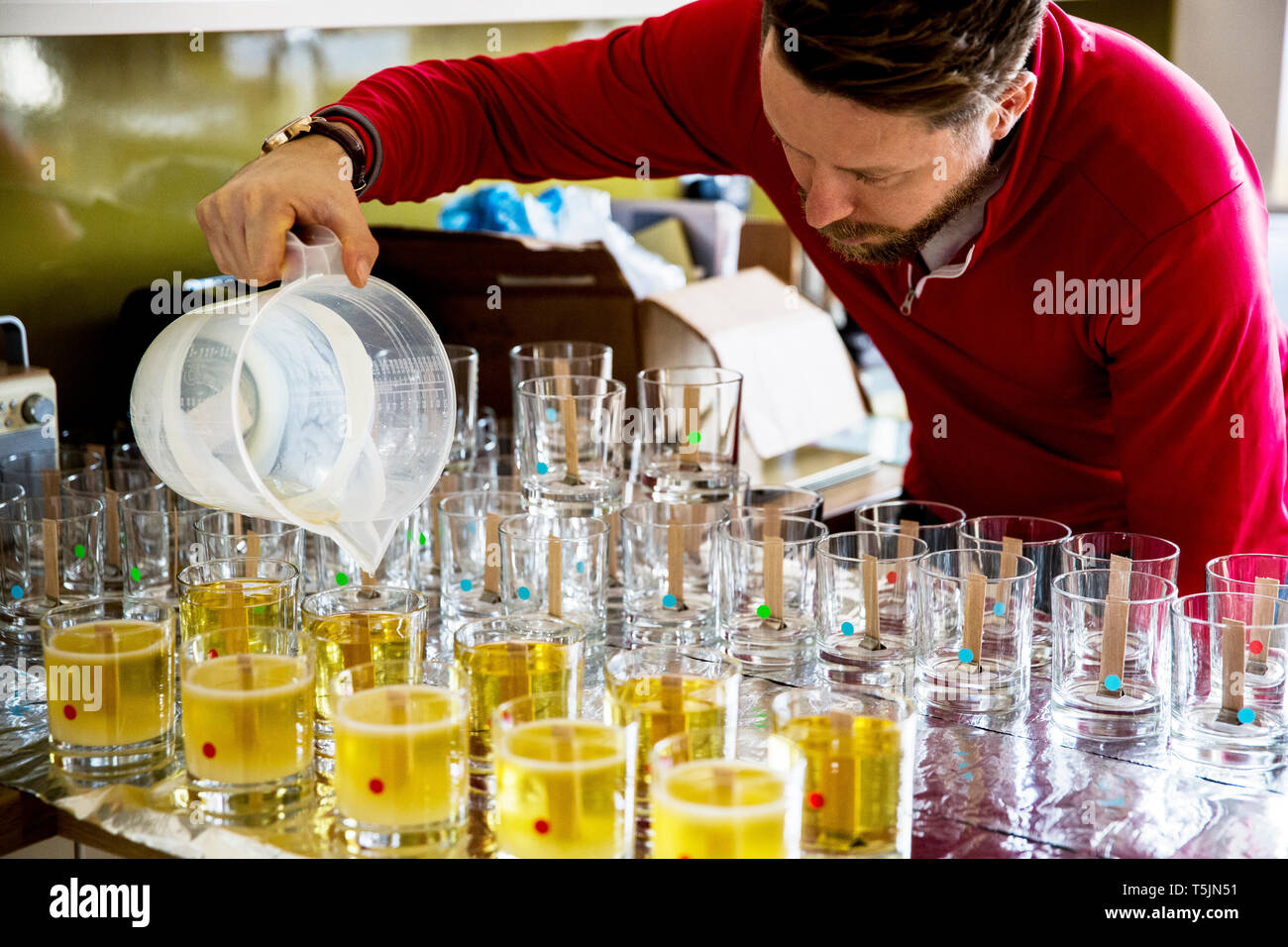 Mann in einem heimischen Küche, sodass jar Kerzen. Stockfoto