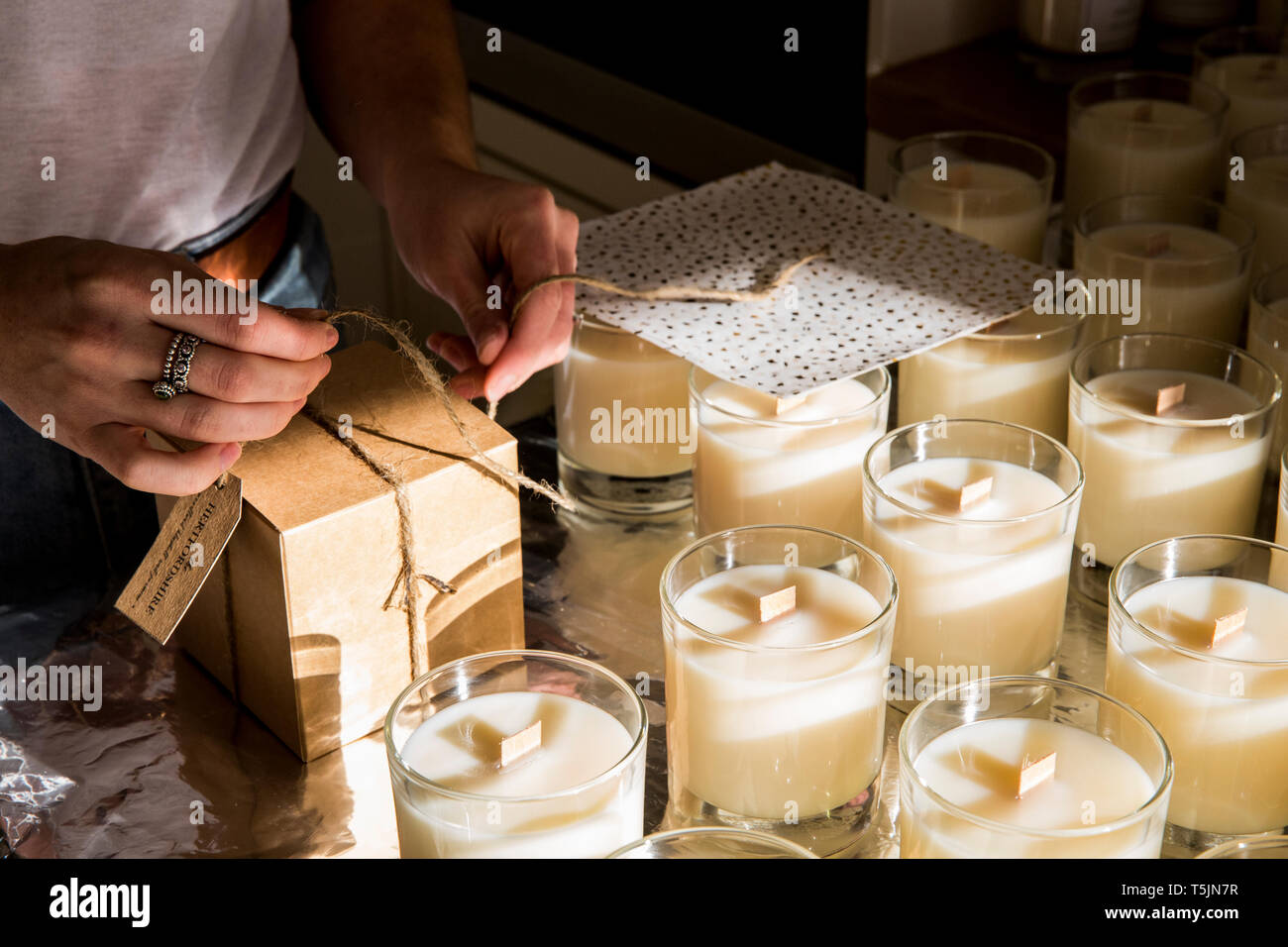 Hohen Winkel in der Nähe der Person einwickeln handgemachten weißen jar Kerzen. Stockfoto