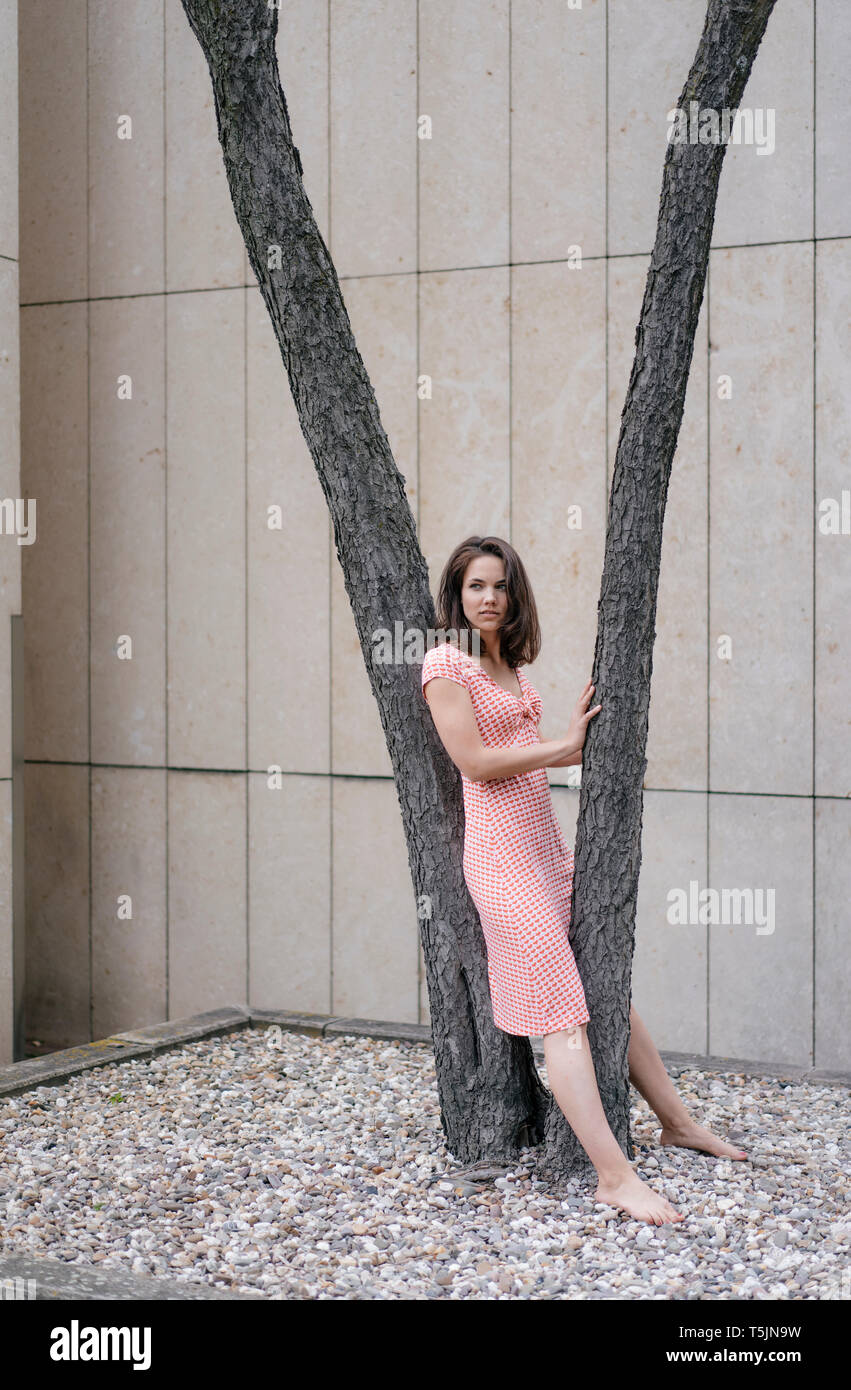 Frau am Baum gelehnt Stockfoto