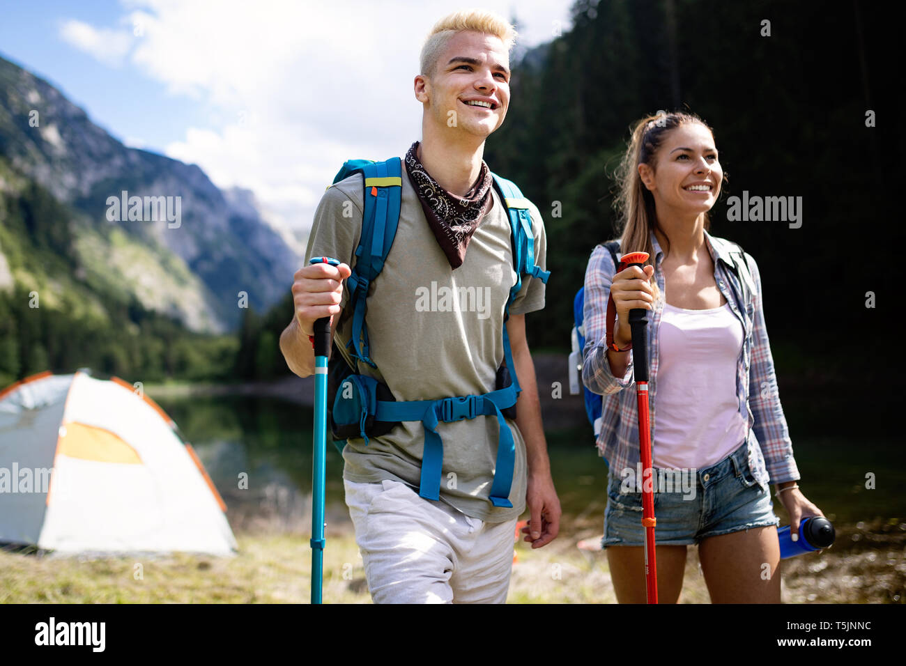 Lächelnd Freunde gehen mit Rucksäcken. Abenteuer, Reisen, Tourismus, Wandern und Menschen Konzept. Stockfoto