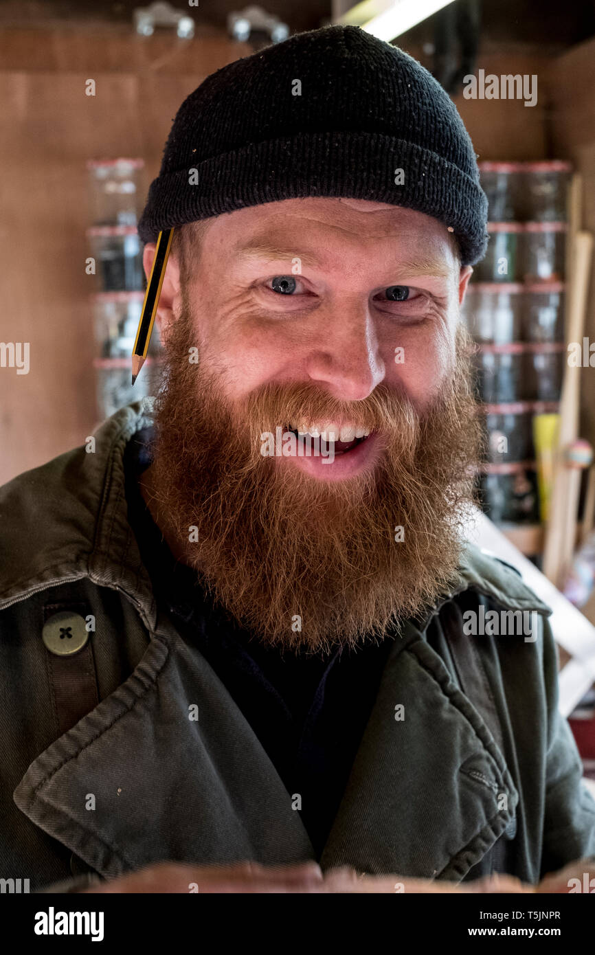 Portrait von lächelnden bärtiger Mann mit hellbraunem Haar, trug schwarze Mütze. Stockfoto