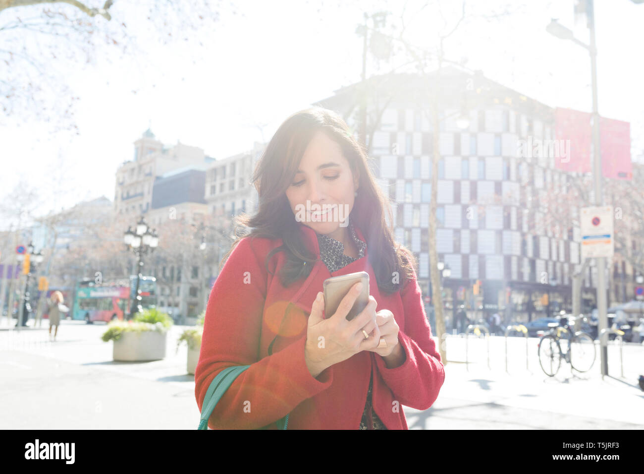Frau mit Handy in der Stadt Stockfoto