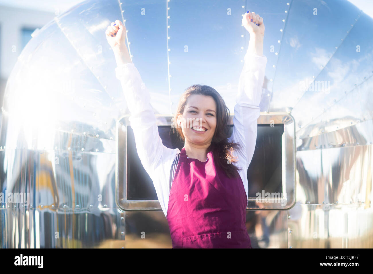 Porträt der glückliche junge Frau an einem Essen Lkw mit Schürze Stockfoto