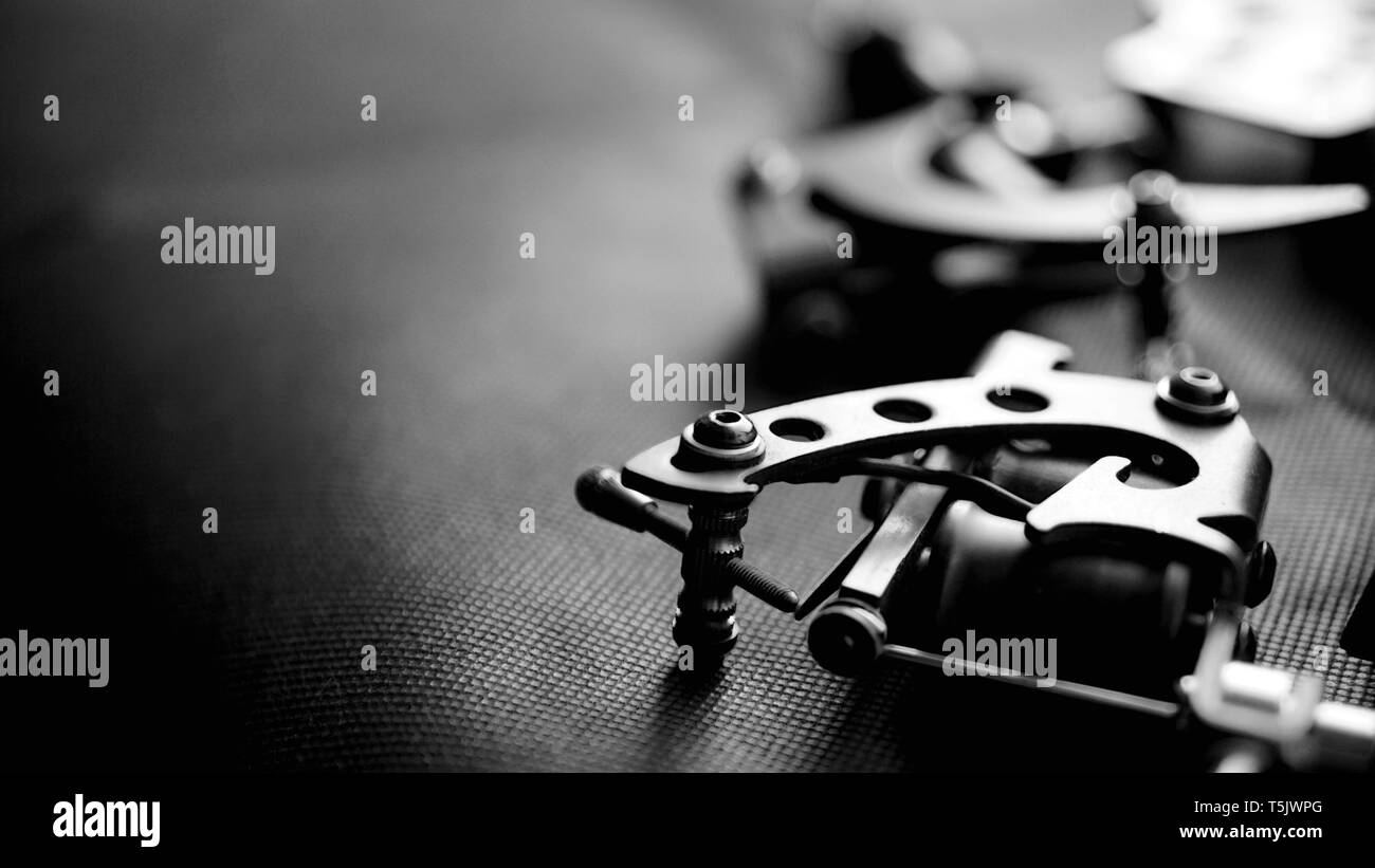 Tattoo Maschine und tätowierungaustattung auf dunklem Hintergrund - für Banner Stockfoto