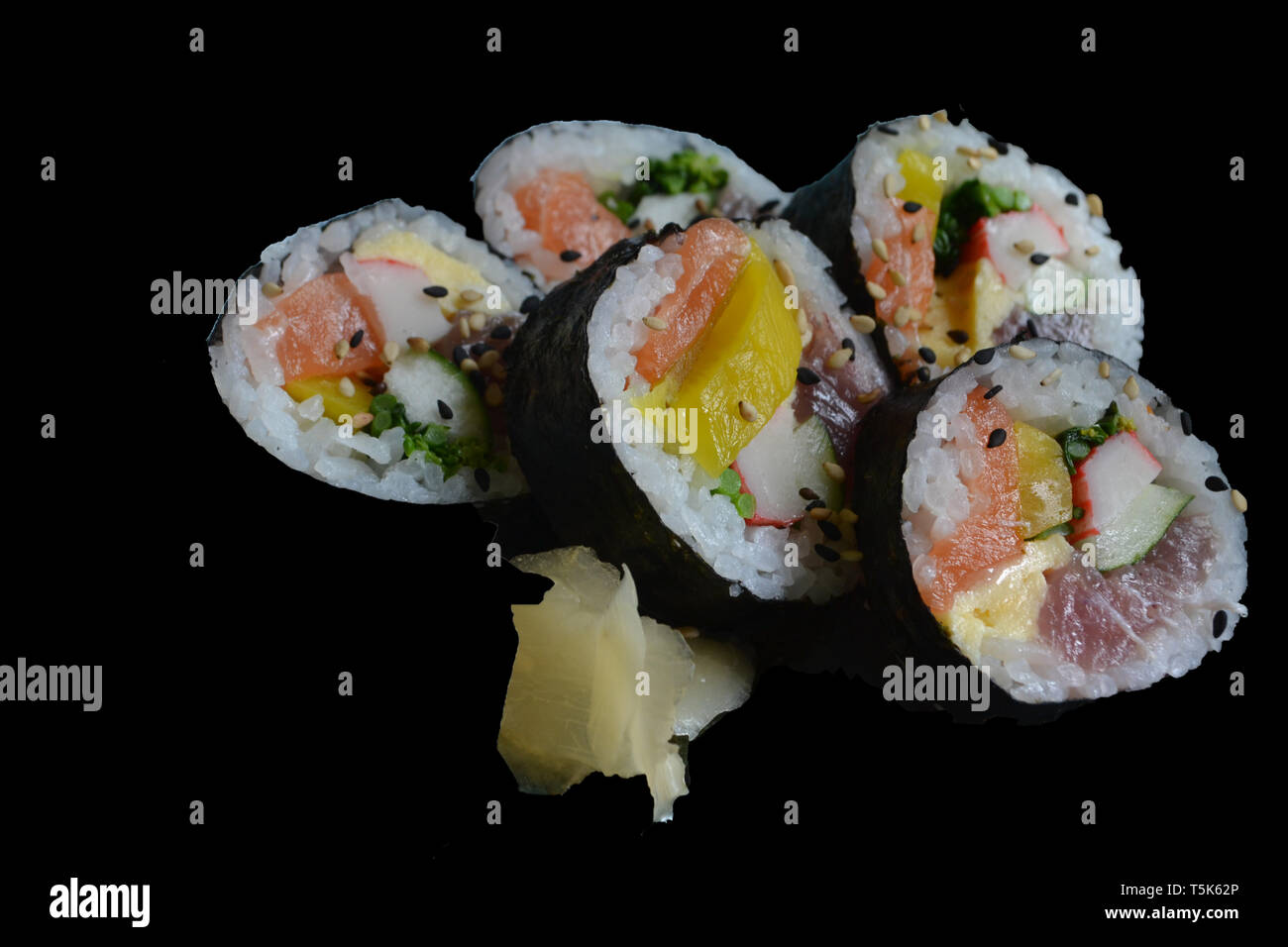 Tradicional shushi mit Lachs, Mango und Kani in einem schwarzen Hintergrund Stockfoto