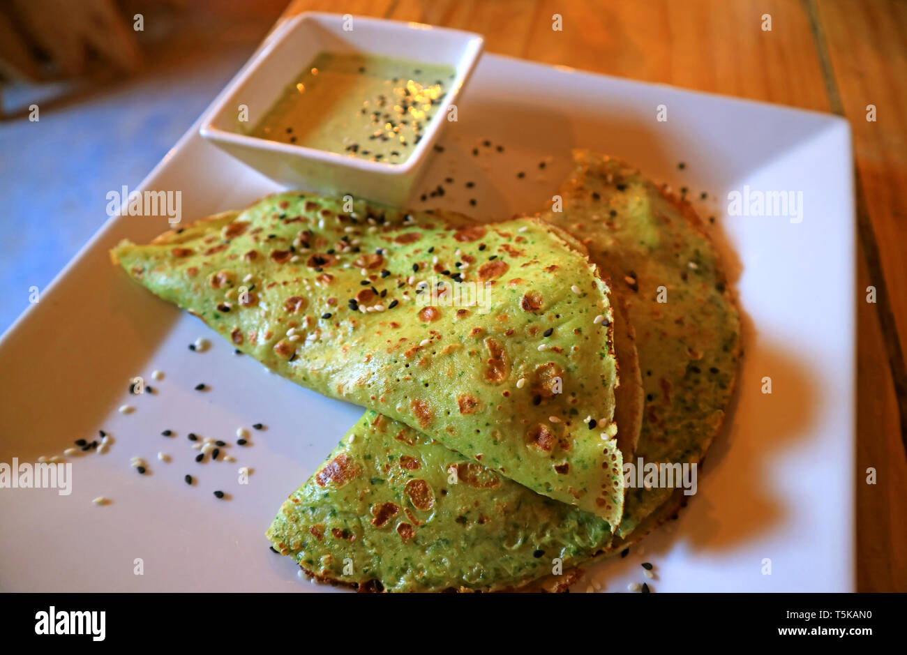 Herzhafte Crepes mit Spinat Grün Senfsauce serviert auf hölzernen Tisch Stockfoto