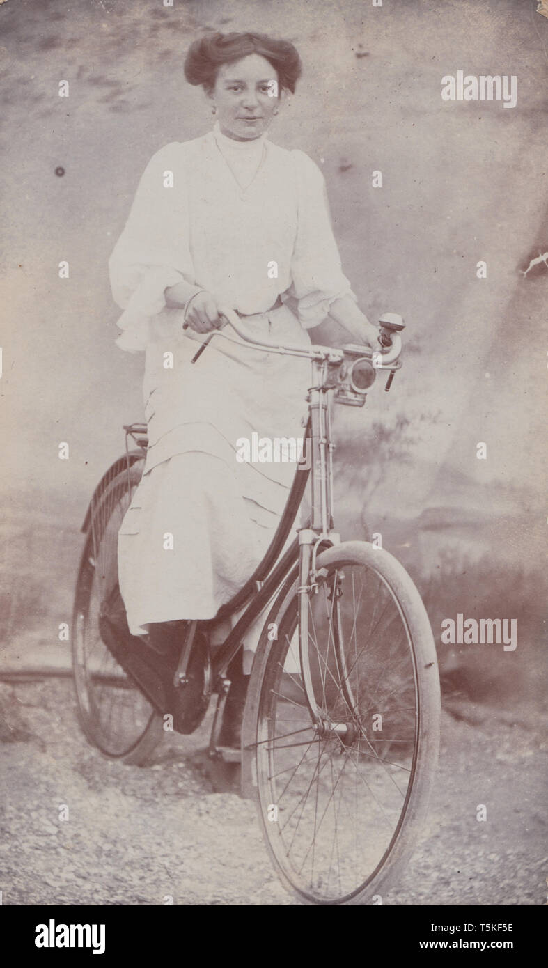 Jahrgang des frühen 20. Jahrhunderts photographische Postkarte einer Frau Reiten Ihr Pedal Cycle Stockfoto