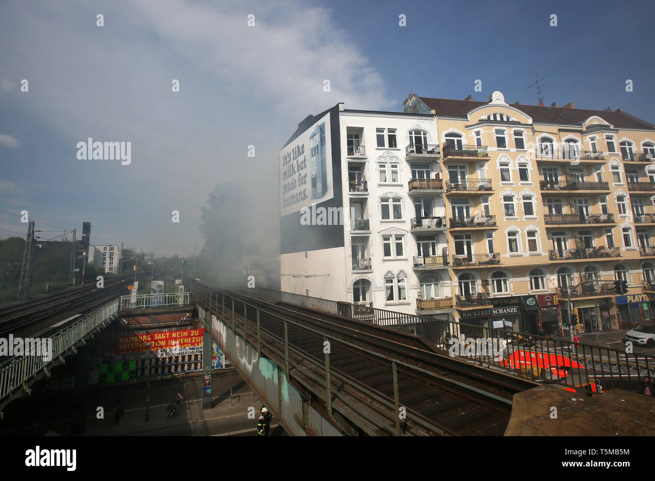 Hamburg, Deutschland. 26 Apr, 2019. Bei einem Brand in einem Mehrfamilienhaus, Rauch kreuzt die Gleise der S-Bahnhof Sternschanze. Ein Feuer war in einem 6-stöckigen Haus in das Schanzenviertel gebrochen. Das Feuer brach in einem Shop Büro im Erdgeschoss, ein Sprecher der Feuerwehr sagte, zunächst aus unbekannten Gründen. Der Rauch breitete sich dann schnell im Treppenhaus. Nach Angaben der Feuerwehr, der Eisenbahnverkehr wurde beeinträchtigt aber nicht unterbrochen. Credit: Bodo Marks/dpa/Alamy leben Nachrichten Stockfoto