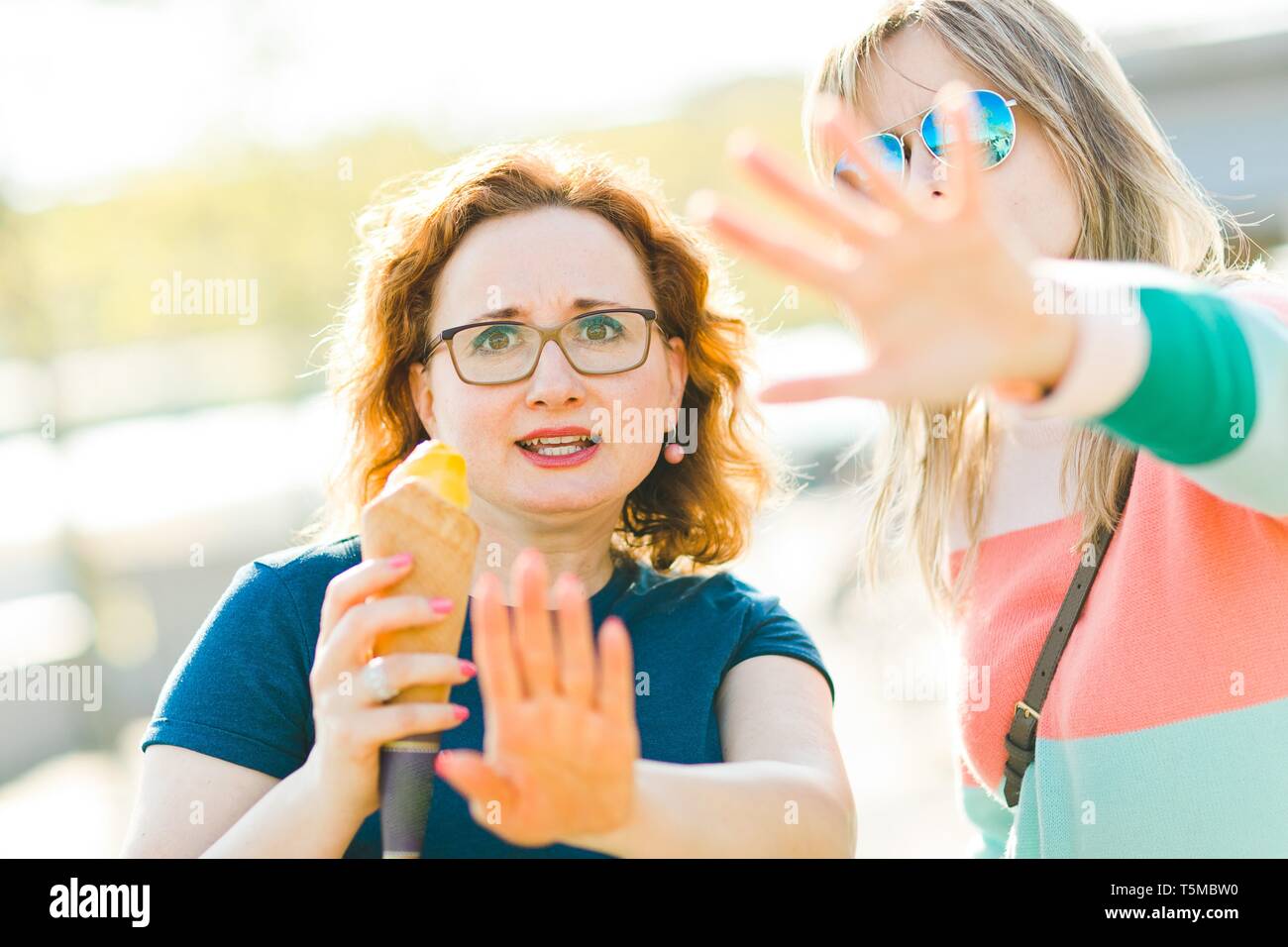Zwei verärgerte Frauen zeigen Gesten kein Foto bitte. Abdeckung mit Händen Stockfoto