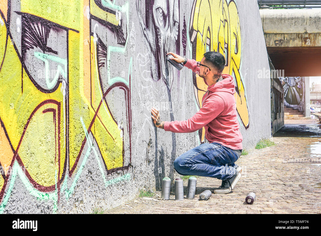 Street Graffiti Künstler Malen mit einem Color Spray einen dunklen Monster Schädel Graffiti an der Wand in der Stadt kann im Freien Stockfoto