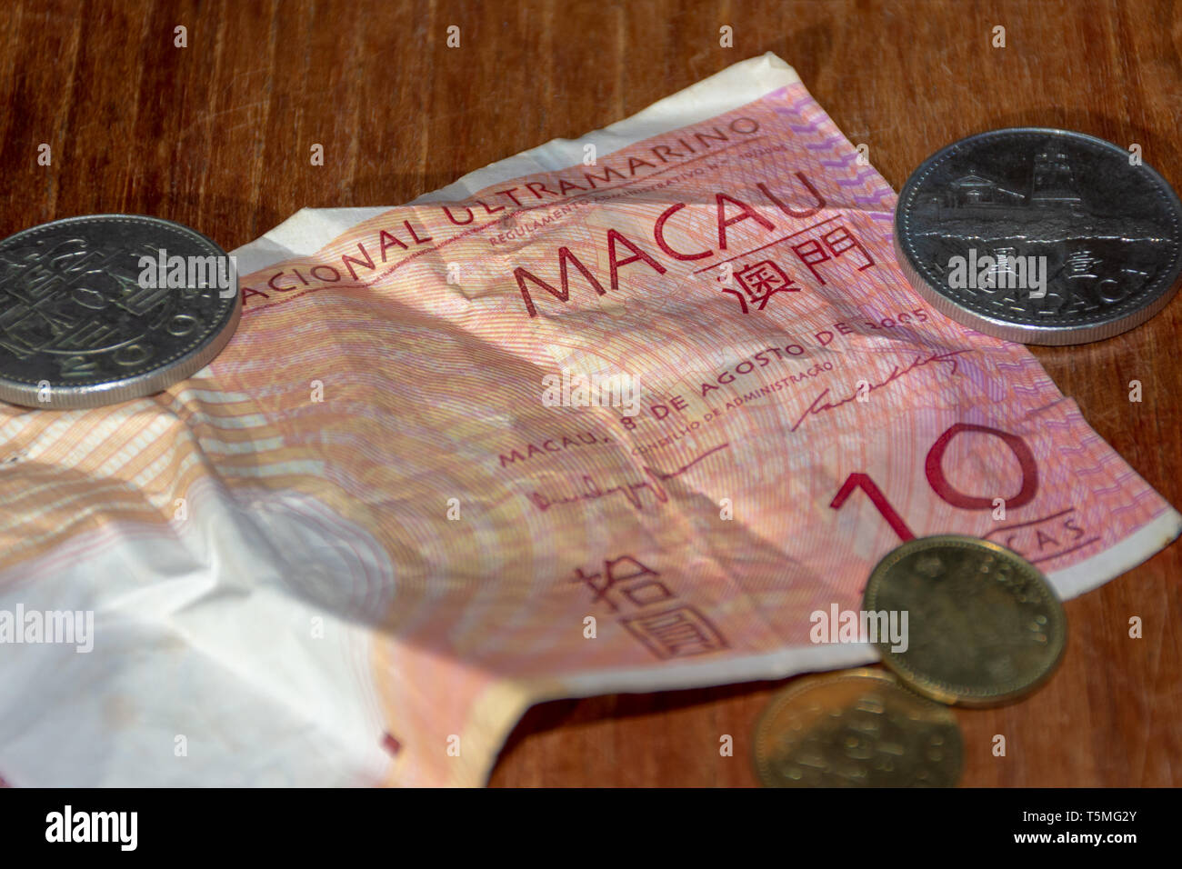 Macau Pataco Bill und Münzen auf den Tisch. Stockfoto