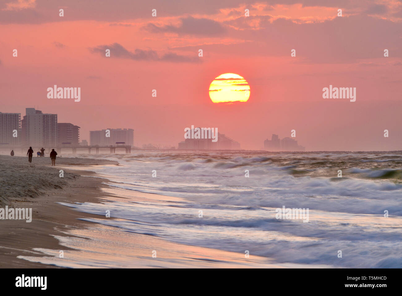 Helle Sonnenaufgang, mit Wolken, Strand entlang über den Atlantik mit Wellen entlang der Küste brechen, in Gulf Shores, Orange Beach, Alabama, USA Stockfoto