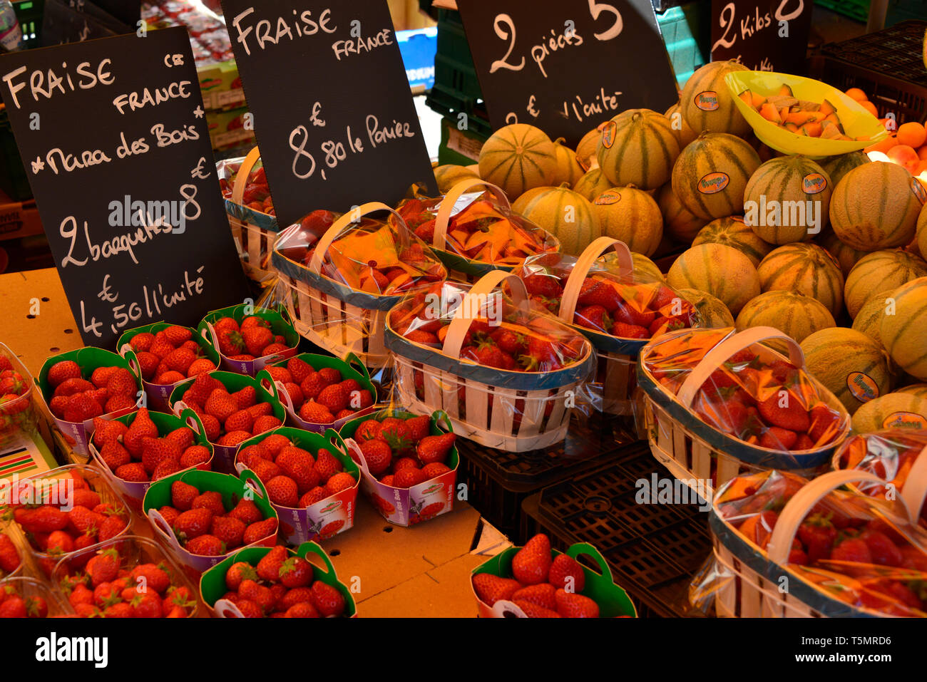 Nahaufnahme der französischen Erdbeeren und Melonen, die in einem Markt mit Preisen in Euro, mit Kreide auf einer Tafel geschrieben. Stockfoto