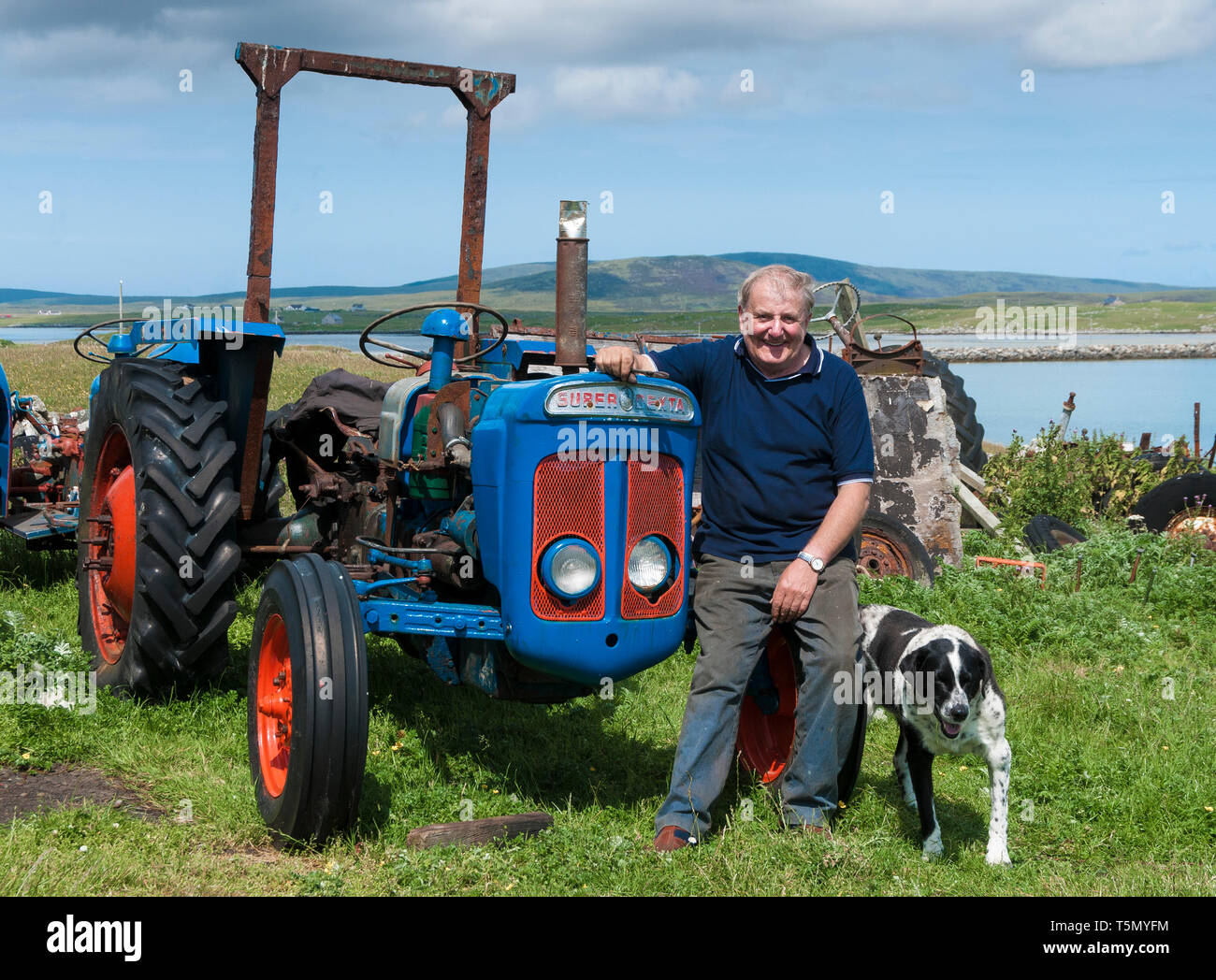 Fordson Dexta und crofter Angus McDonald mit seinem Hund, North Uist Stockfoto