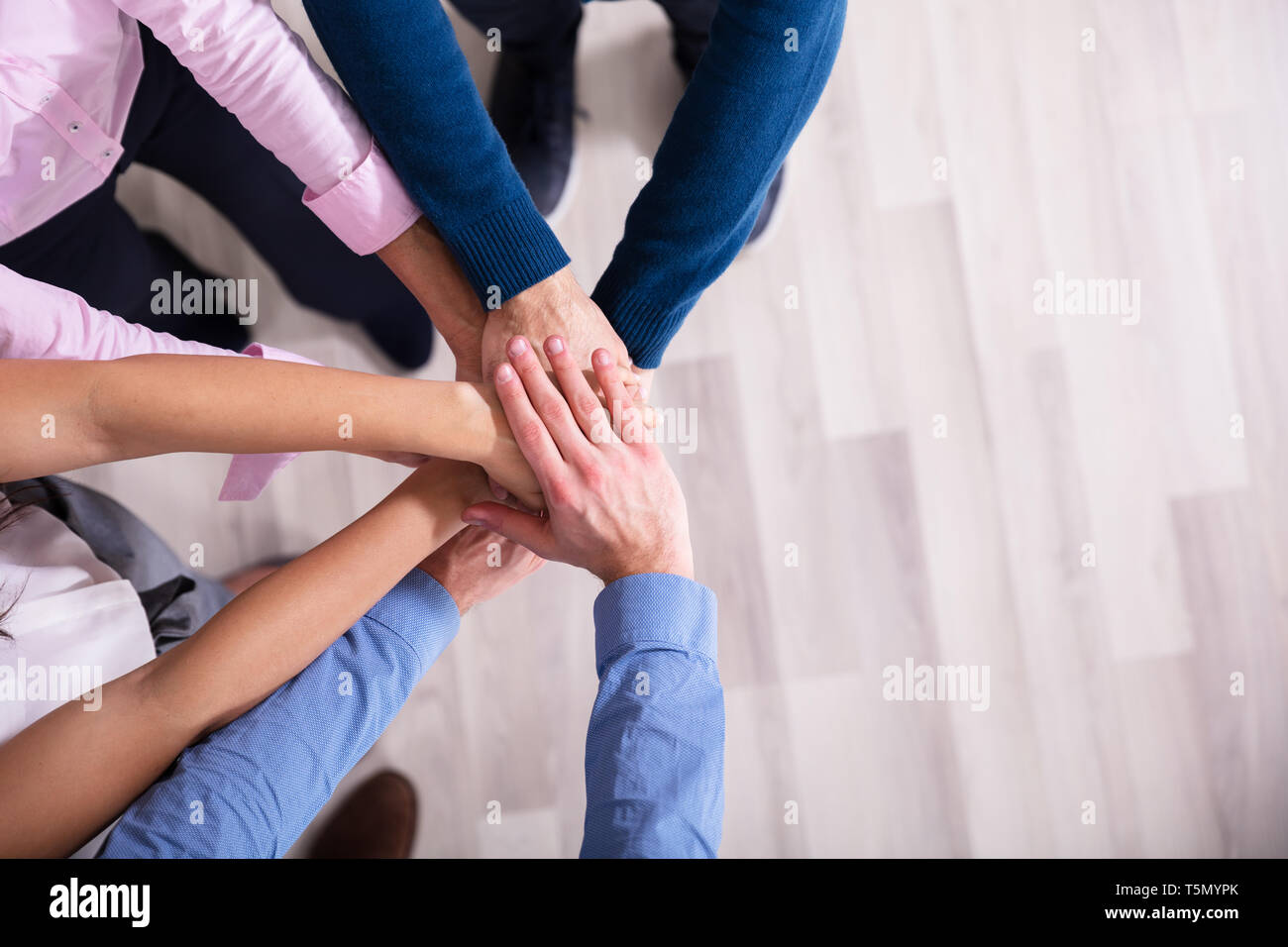 Einen erhöhten Blick auf Geschäftsleute, die Hände übereinander stapeln Stockfoto