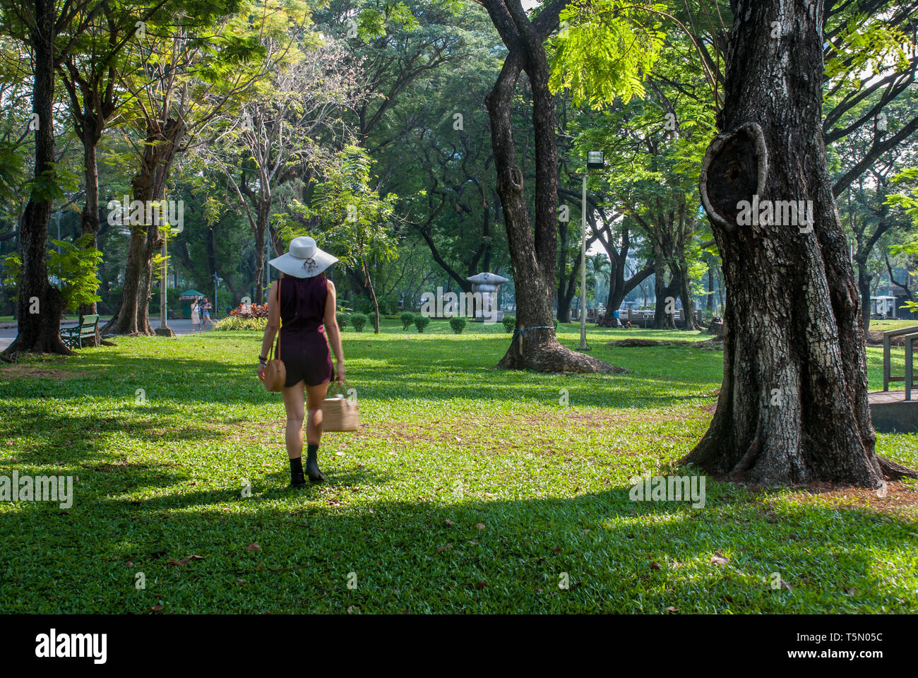 Eine schöne Frau ist ein Sitz im Garten zu finden. Stockfoto