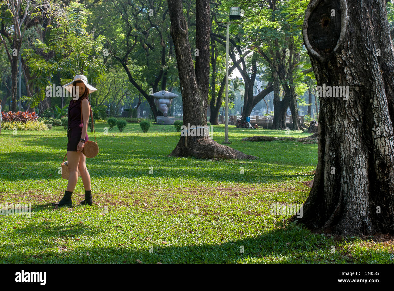 Eine schöne Frau ist ein Sitz im Garten zu finden. Stockfoto