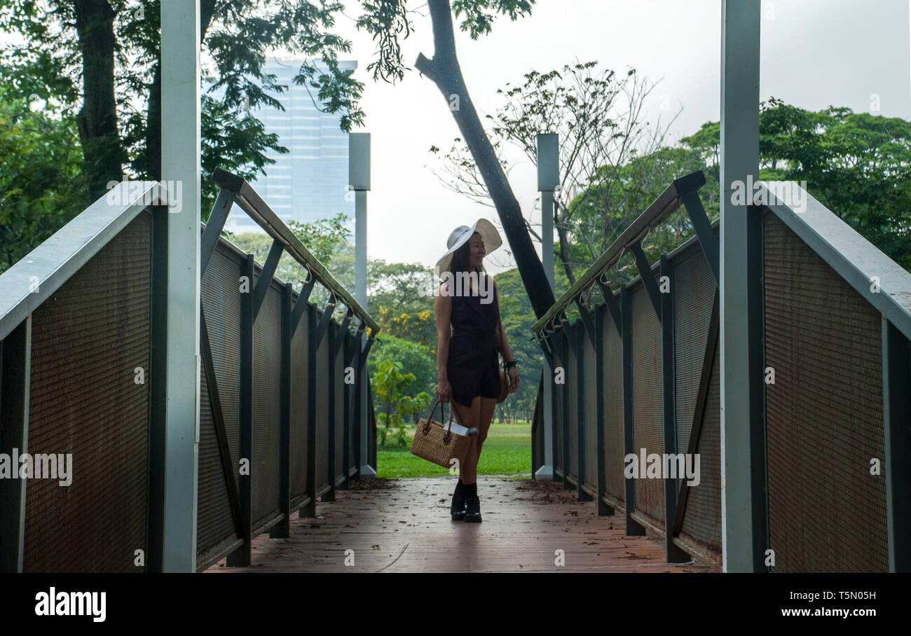 Eine schöne Frau ist ein Sitz im Garten zu finden. Stockfoto