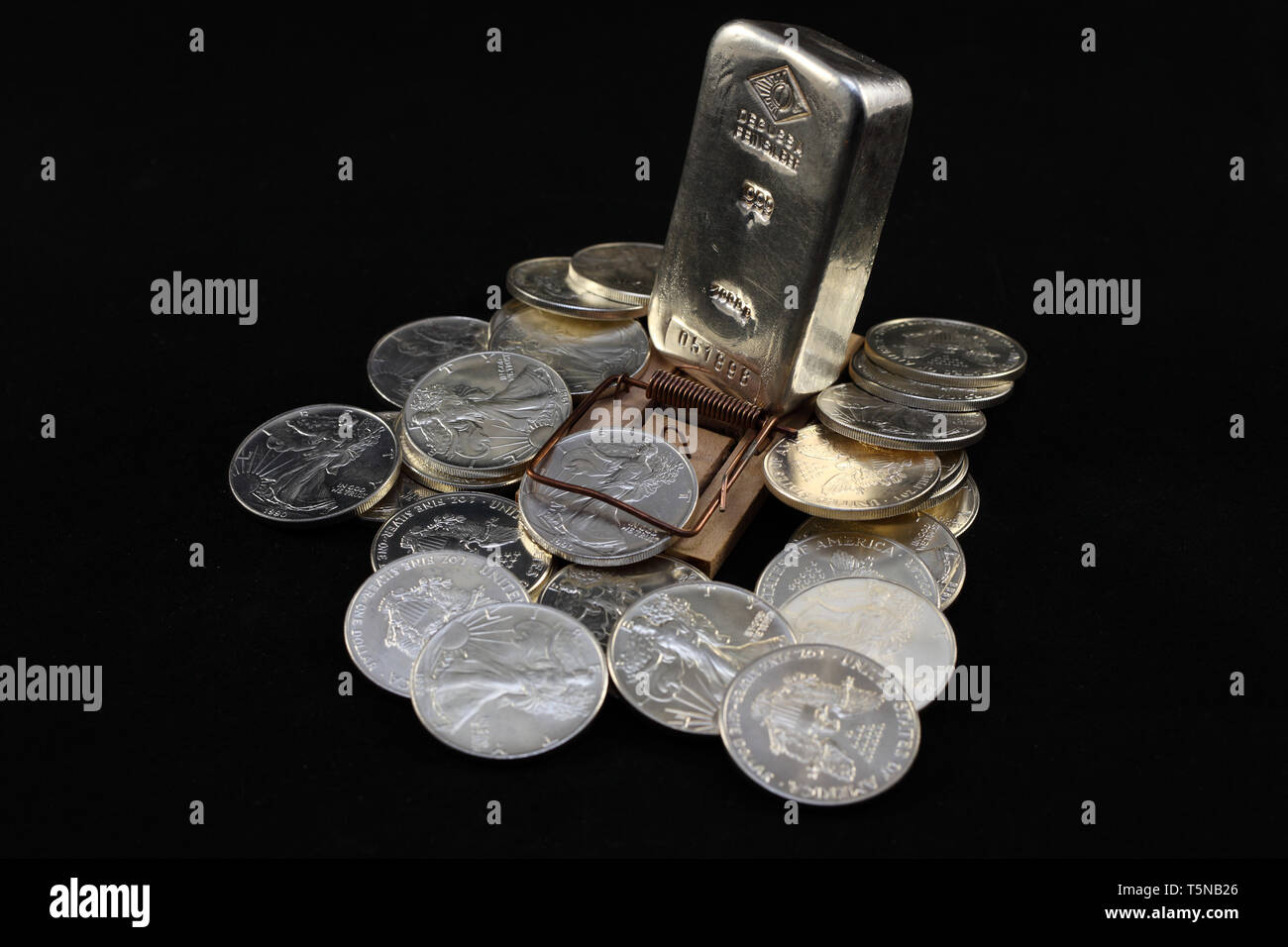 Silbermünzen und Silberbarren in einer Mausefalle Stockfoto