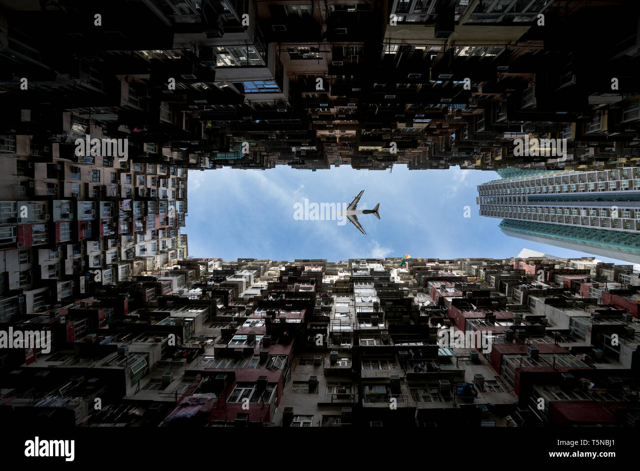 Hong Kong City Residenzen. Low Angle View Bild von einem überfüllten Wohnhaus in Gemeinschaft mit dem Flugzeug Fliegen über in Quarry Bay, Hong Kong Stockfoto