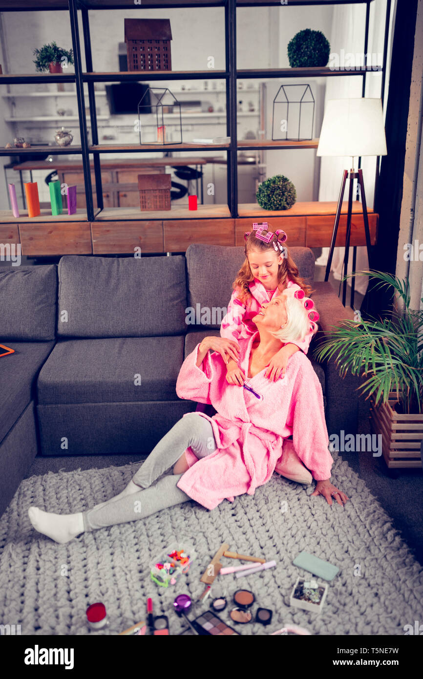 Oma und Mädchen mit rosa Bademäntel in Schönheit Tag zu Hause Stockfoto