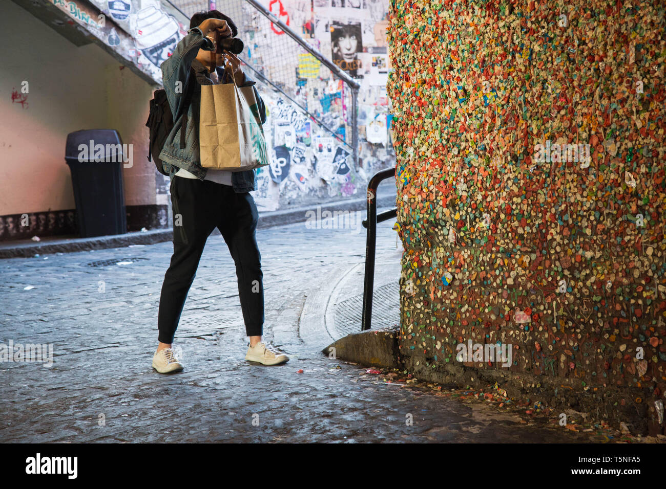 Die männlichen Touristen mit einem Starbucks Kaffee Shopping Bag in seiner Hand, konzentriert sich die Bilder von der Gummi Wand in Seattle, USA. Stockfoto