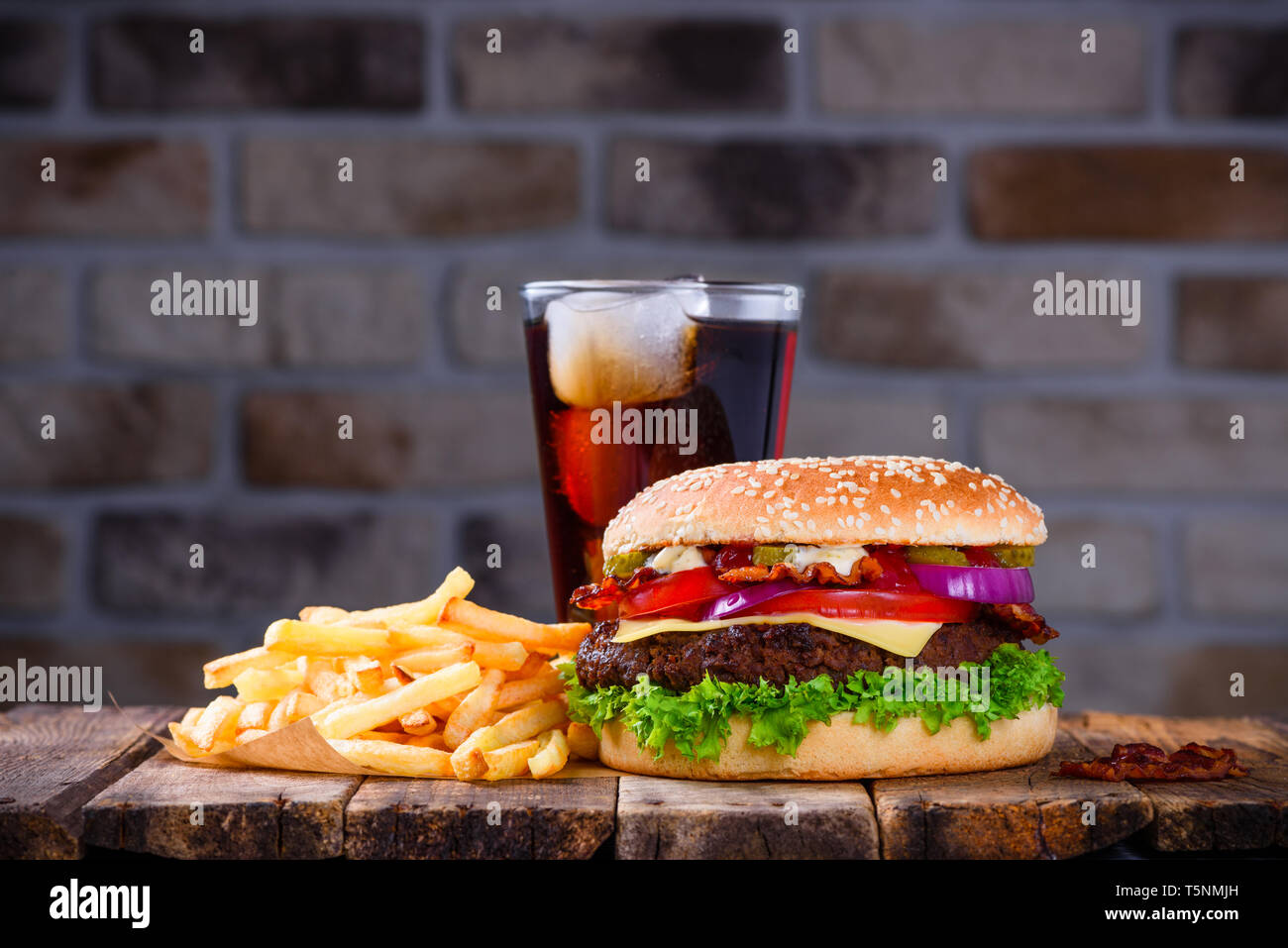 Hamburger mit Pommes Frites und Cola auf hölzernen Tisch Stockfoto