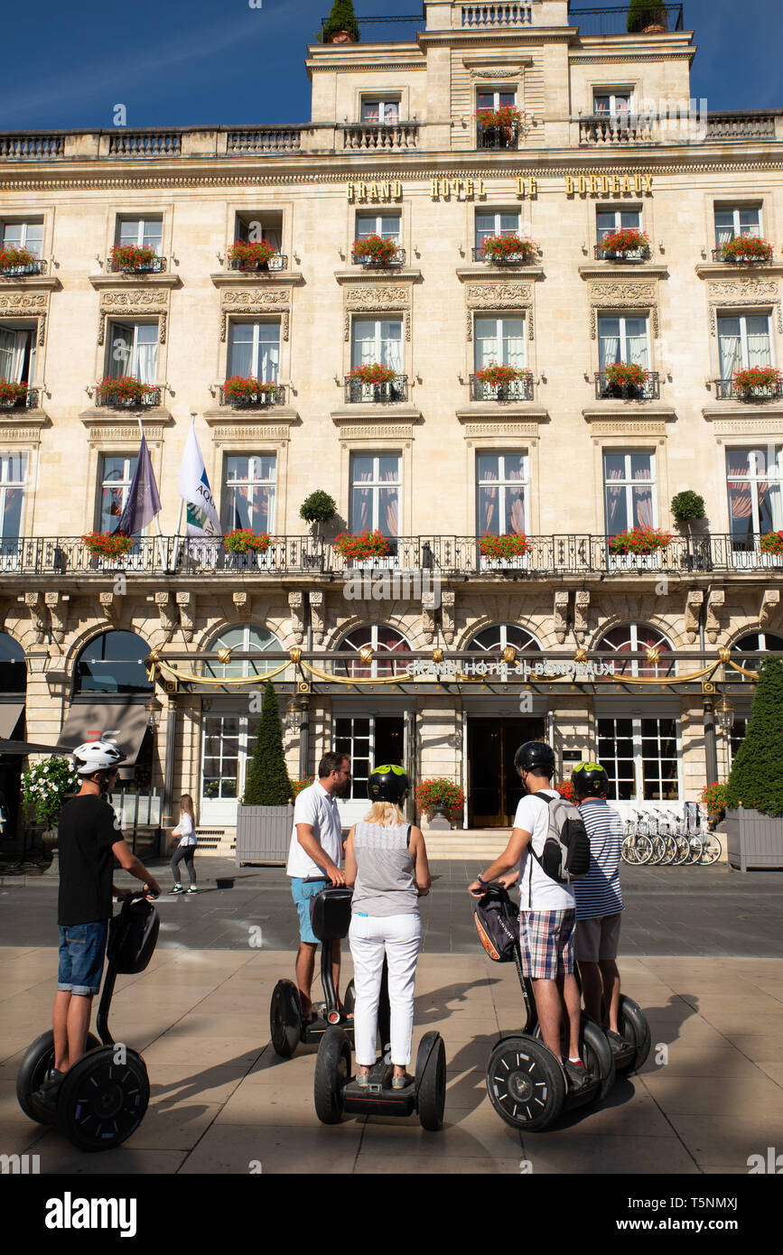 Touristen auf Sedgways vor dem Grand Hotel de Bordeaux, Gironde, Frankreich. Stockfoto