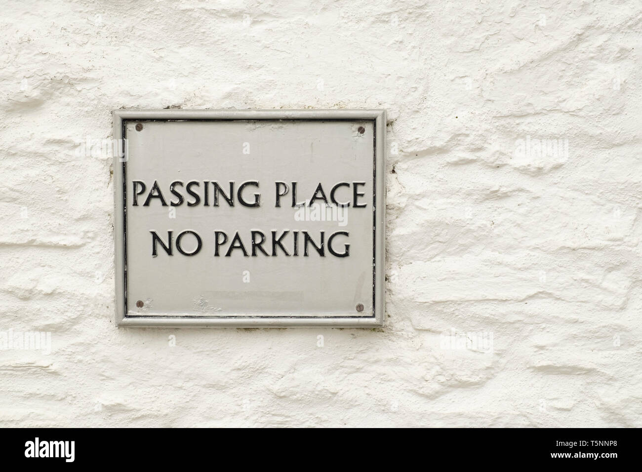 Kein Parkplatz Schild und vorbei an Ort unterzeichnen, an der Wand in Durgan Dorf, Cornwall, England Stockfoto