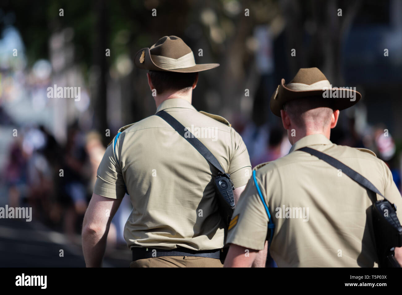 Zwei junge Soldaten gerne zu Fuß zu Ihrem Treffpunkt für die Veranstaltung in voller Uniform mit ihren Hüten und Gewehren gekleidet Stockfoto