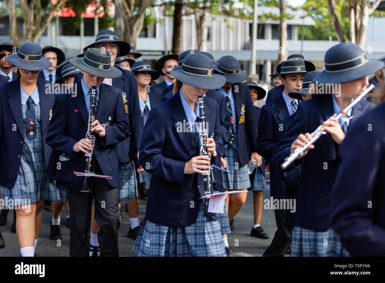 Lokale private Schule Kinder Durchführung und Teilnahme an der Anzac Day street März, im vollständigen formalen Uniform gekleidet Stockfoto