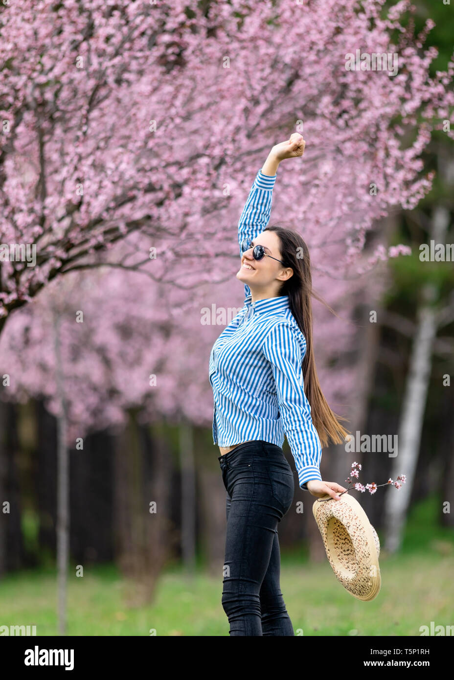 schöne junge Frau in blühenden Kirschbaum-Blüten-Garten Stockfoto